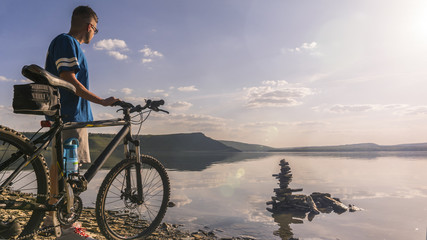 Fototapeta na wymiar Man standing with sport bike behind beautiful landscape
