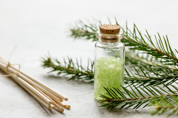 spa with organic spruce sea salt in glass bottles on white table background