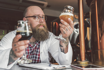 Concentrated bearded man standing in brew house