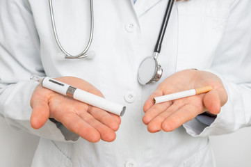Doctor is comparing an e-cigarette and tobacco cigarette