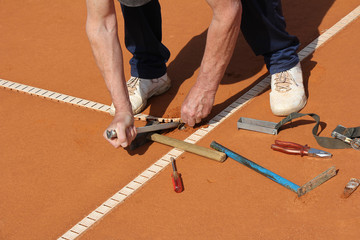 Worker Repairing lines on a tennis court © smuki