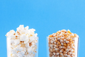 Popcorn and corn kernels on a blue background