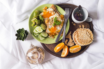 Fried eggs with toasts and tea in bed
