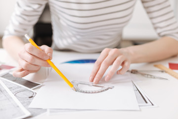 Skillful female engineer using a protractor