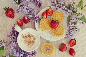  Cup of cappuccino with waffles, strawberries and flowers