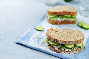 Ricotta sprouts avocado cucumber rye sandwich