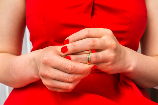 Woman is taking off her wedding ring - divorce concept