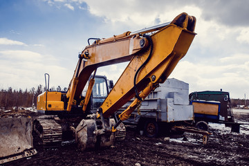 Excavators machine and bulldozer loader in construction site on sky background. Concept machines for construction.