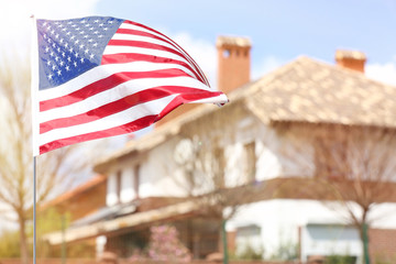 Waving USA flag and blurred house on background