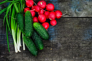 Radish cucumbers and green onion on wooden table. Top view