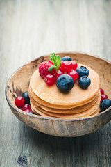 Stack of pancakes with blueberry and fresh berry.