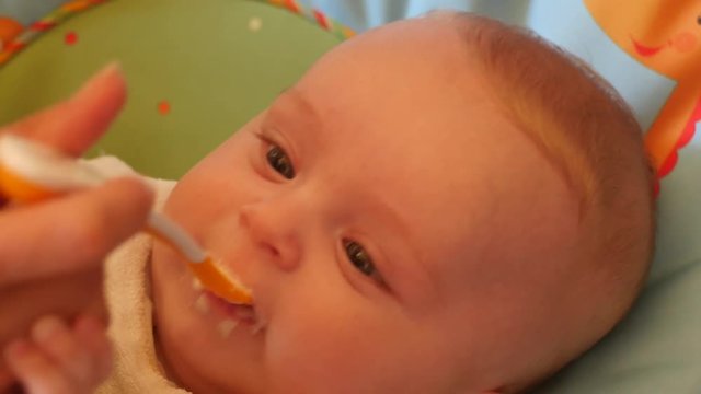 cute baby first time feeding with spoon