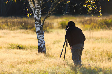 Nature photographer in the field with his DSLR camera