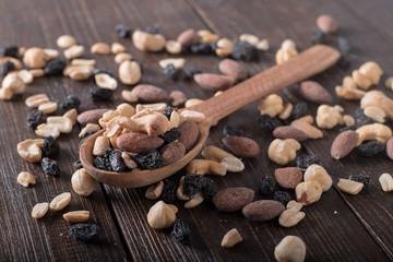 Dried fruits with nuts in a spoonon a wooden background.
