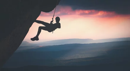 Foto op Canvas Climber on a cliff against misty mountains. Instagram stylisation © Bashkatov