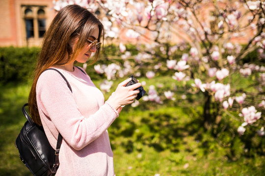 women traveler use camera take a photo magnolia blossoms