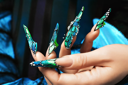 Fototapeta Hand of the girl. Female manicure. Long colored acrylic nails.