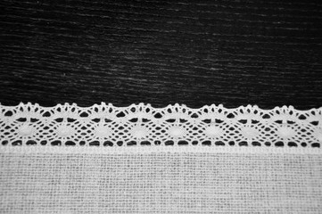 Beautiful black and white lacy lace white embroidery linen textile on wooden desk background