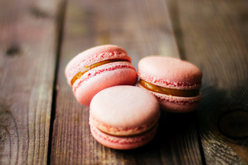 Fresh baked purple pink macaroon pastry cookies macarons, macaroni in retail store display, close up, low angle view.
