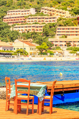 Fototapeta premium Table and chairs next to the beach in Corfu, Greece