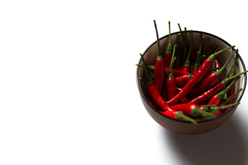 Red hot chillies in a bowl isolated over white background