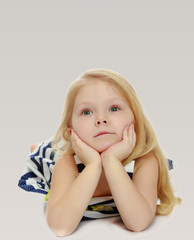 Girl in striped dress lying on the floor.