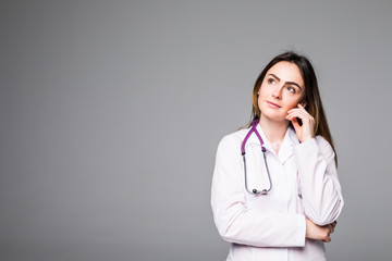 Friendly smiling young female doctor on grey background