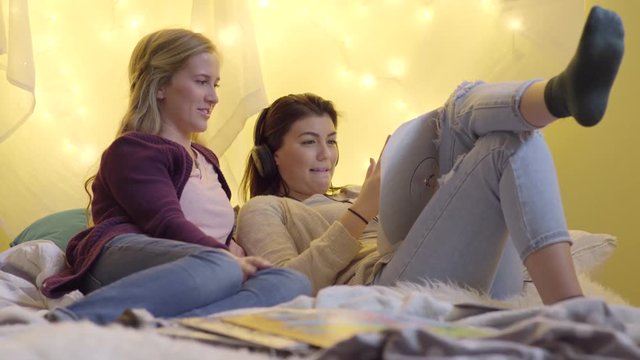 Teen Listens To Music With Headphones, She Watches Music Video On Her Phone And Dances Along, Her Friend Laughs