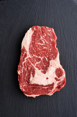 Fresh raw Prime Black Angus beef steak on stone background