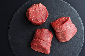 Three fresh raw Prime Black Angus beef steaks on stone background