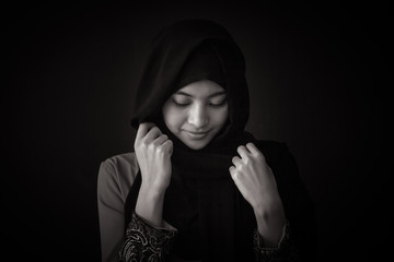 Portrait of beautiful young muslim woman on a black background. Black and white tone