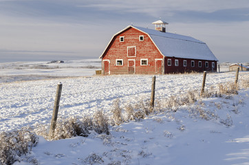 Old red barn in a snow-covered winter wonderland scene