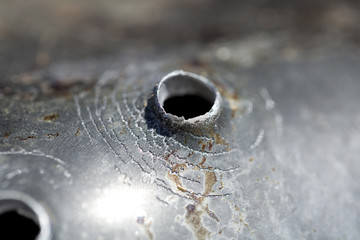 Bullet holes after a target shooting on a pan.