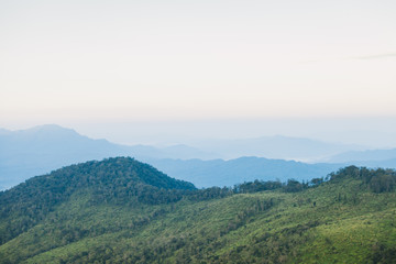 Beautiful autumnal landscape with sunrise over a foggy valley and mountain ranges.