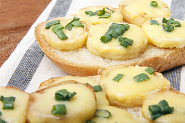 Appetizer of wheat bread, potatoes, cheese and green onions