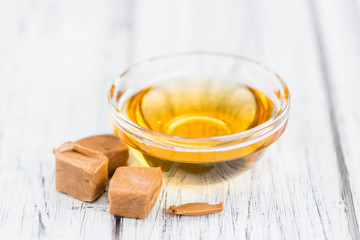 Caramel Syrup on wooden background (selective focus)