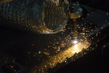 The laser cutter machine while cutting the sheet metal with the sparking light
