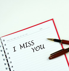 Communication message motivation concept with " I MISS YOU " word on notebook.