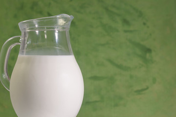 Fresh cow milk in a jar on a light background.