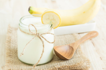 Yogurt in glass bottles on wooden table