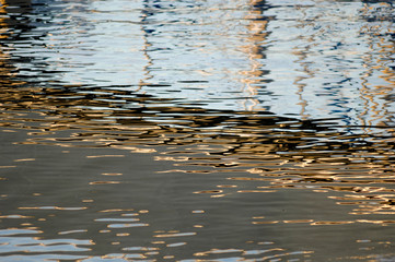 Reflection of boat in calm harbor water