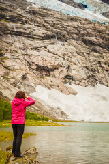 Tourist admiring Boyabreen Glacier in Norway