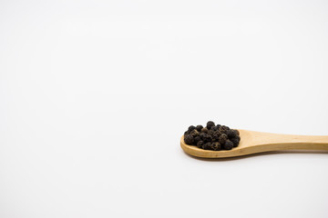 Fototapeta na wymiar Black Peppercorn in wooden spoon over white background.