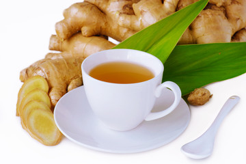 ginger tea with sliced root and leaf on wooden table.