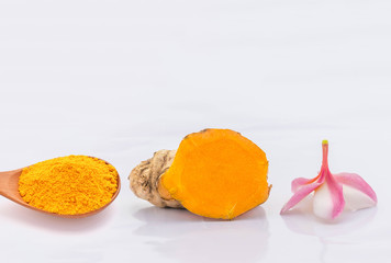 Abstract soft blurred and soft focus of Turmeric powder on the wooden spoon, Zingiber,Turmeric root, Cassumunar ginger, Bengal root,Zingiberaceae,Plumeria flower , with the white background. The local