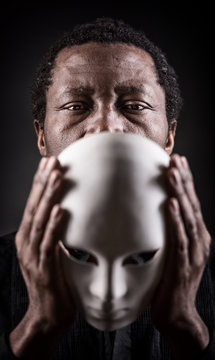 Dramatic art portrait of african black man with white mask.