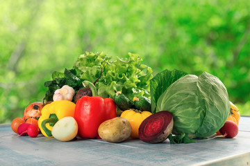 Different raw fresh vegetables оn blue rustic wooden table