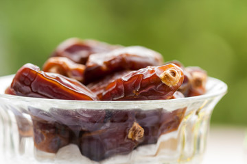 Close up of date fruits in a glass bowl. Ramadan, Eid concept background
