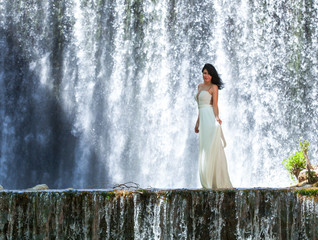 Fototapeta na wymiar Schöne junge Frau vor malerischen Wasserfall