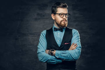 Successful bearded male with crossed arms, dressed in elegant shirt and waistcoat.
